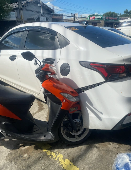 Motorcycle crashed into our parked car
